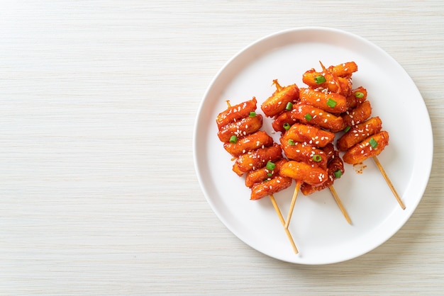 frittierter koreanischer Reiskuchen (Tteokbokki) mit scharfer Sauce aufgespießt