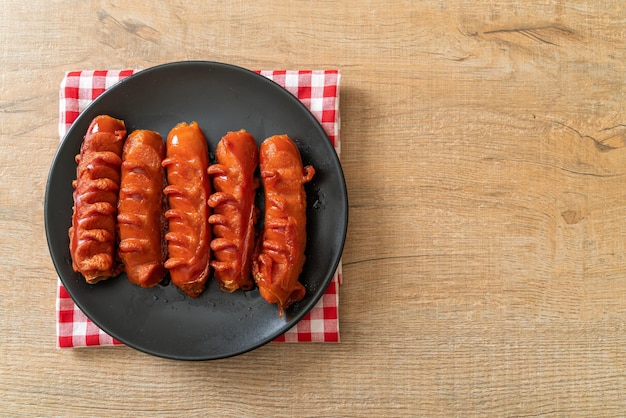 frittierter Wurstspieß auf schwarzem Teller