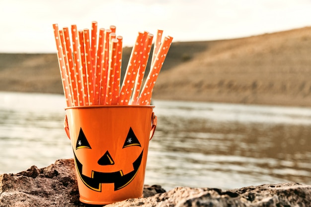 Foto fröhlich halloween eimer mit orange strohhalme