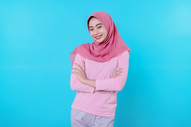 Fröhlich lächelnde Frau mit attraktivem Aussehen und tragendem Hijab, rosa T-Shirt, das gute Laune zeigt