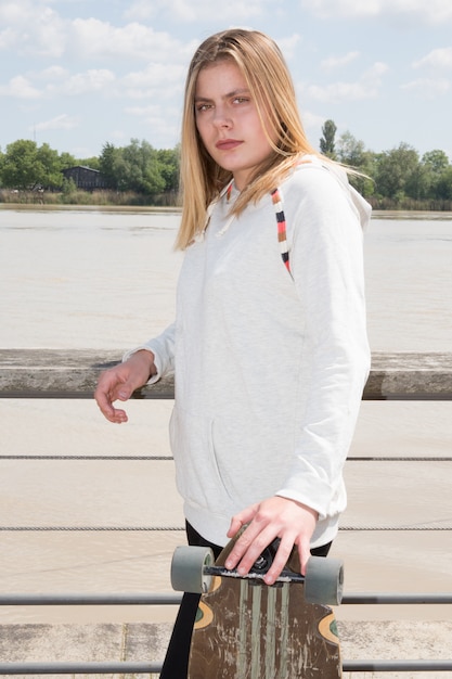 Fröhlich Teenager in der Stadt mit Skateboard