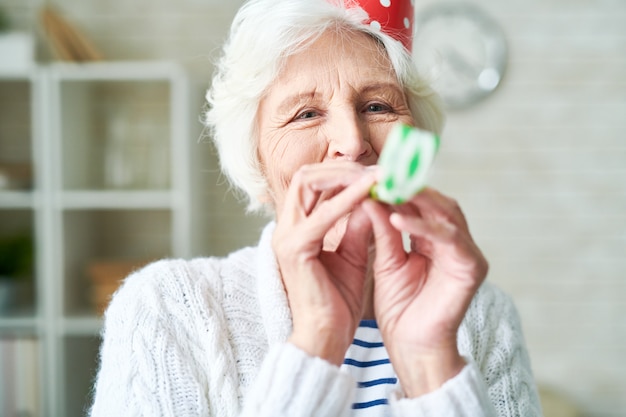 Fröhliche ältere Frau, die ihren Geburtstag feiert