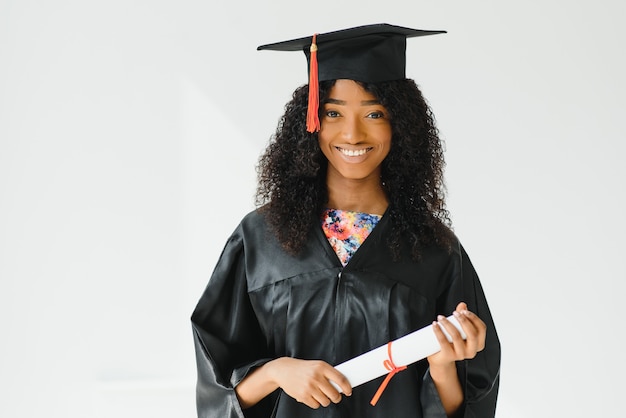 Fröhliche afroamerikanische Doktorandin mit Diplom in der Hand