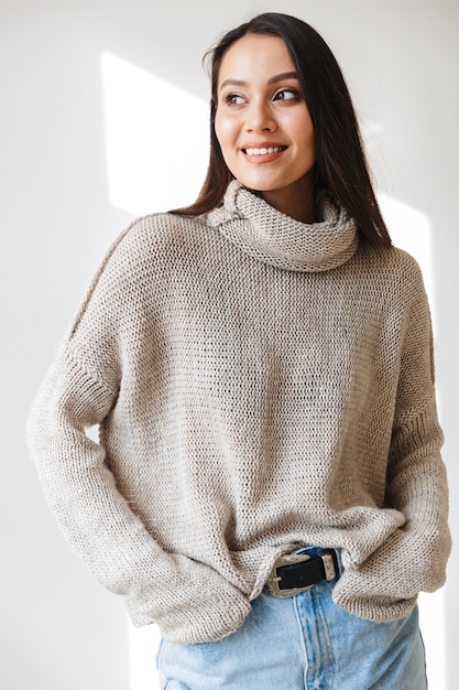 Foto fröhliche asiatische frau, die lächelt und beiseite schaut, isoliert auf weiß