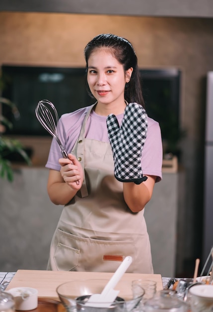 Fröhliche asiatische Frau, die zu Hause hausgemachte Bäckerei kocht Starten Sie ein KMU-Konzept für kleine Unternehmen