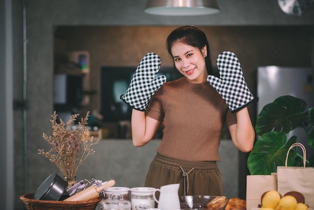 Fröhliche asiatische Frau, die zu Hause hausgemachte Bäckerei kocht Starten Sie ein KMU-Konzept für kleine Unternehmen