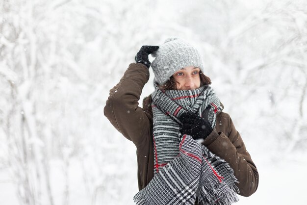 Fröhliche, attraktive Frau in warmer Kleidung bei verschneitem Winterwetter im Freien