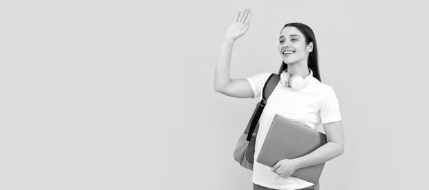 Fröhliche Dame mit Kopfhörern hält PC und trägt Rucksack. Hallo Frau isoliertes Gesichtsporträt-Banner mit Kopie