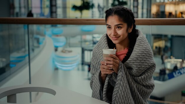 Fröhliche erholsame arabische hispanische ethnische junge Frau Teenager Studentin sitzen im Café-Restaurant-Getränk