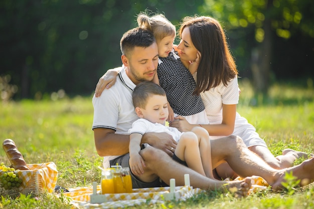 Fröhliche Familie beim Picknick. Eltern essen mit ihren Kindern im Freien zu Abend.