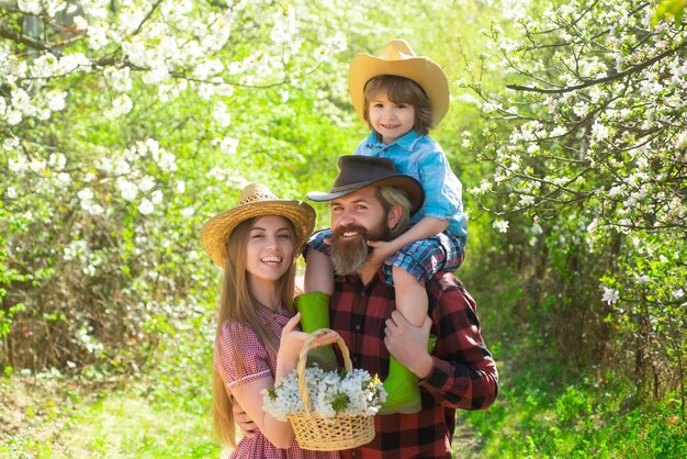 Fröhliche Familie beim Picknick in einem Park Familienbauern, die im Frühling im Baumgarten arbeiten Vater Mutter an