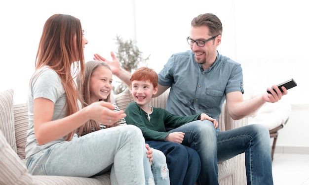 Foto fröhliche familie, die auf der couch im wohnzimmer sitzt