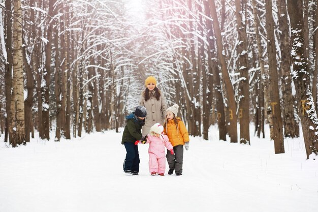 Fröhliche Familie, die im Winter im Freien im Schnee spielt und lacht Stadtpark Wintertag