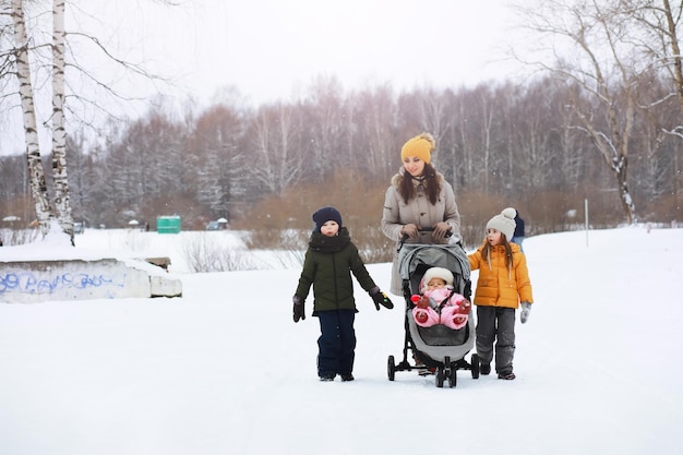 Fröhliche Familie, die im Winter im Freien im Schnee spielt und lacht Stadtpark Wintertag