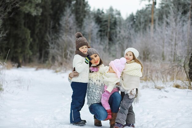 Fröhliche Familie, die im Winter im Freien im Schnee spielt und lacht Stadtpark Wintertag
