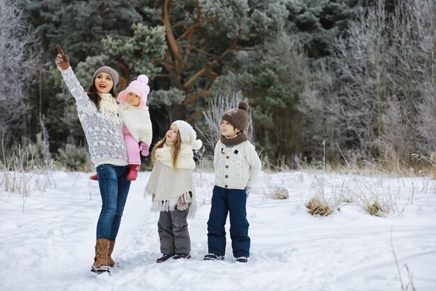 Fröhliche Familie, die im Winter im Freien im Schnee spielt und lacht Stadtpark Wintertag