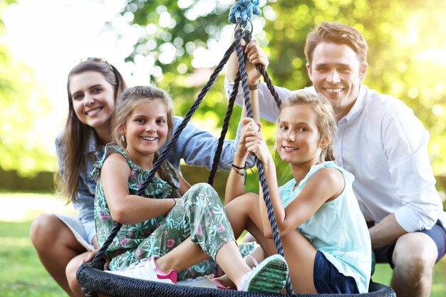 fröhliche Familie, die Spaß auf dem Spielplatz hat