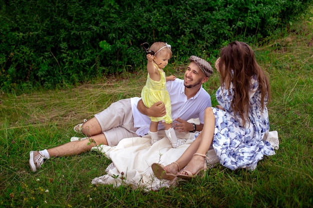 Fröhliche Familie, die Spaß im Park hat. Eltern mit Tochter im Freien entspannen.