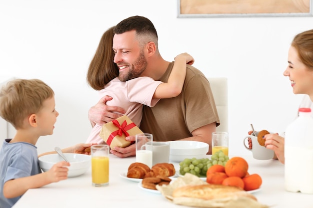 Fröhliche Familie feiert gemeinsam den Vatertag beim Frühstück in der heimischen Küche