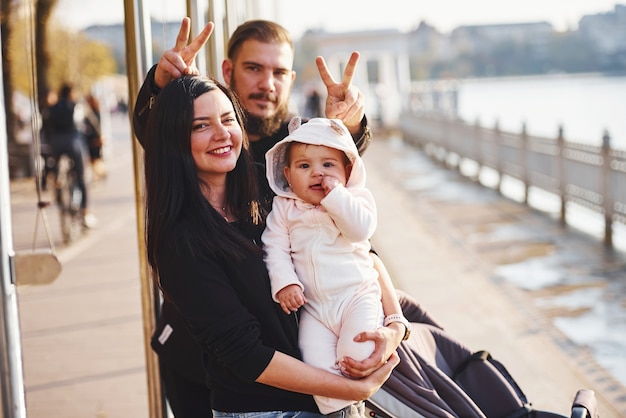 Fröhliche Familie macht zusammen mit ihrem Kind einen Spaziergang im Park.