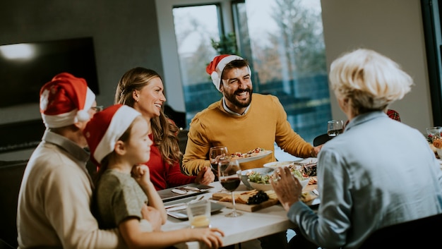 Fröhliche Familie mit mehreren Generationen, die das neue Jahr zu Hause am Tisch feiert