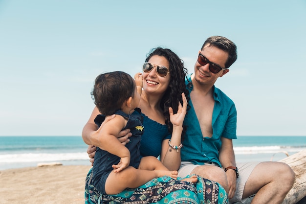 Foto fröhliche familie sitzt am strand