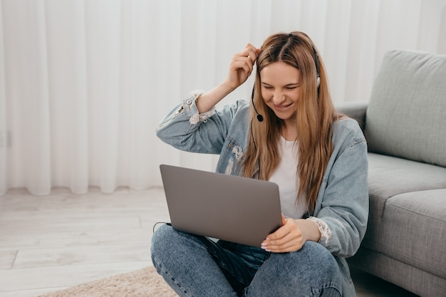 Fröhliche Frau, die am Laptop arbeitet