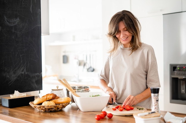 Fröhliche Frau, die auf moderner Küche kocht