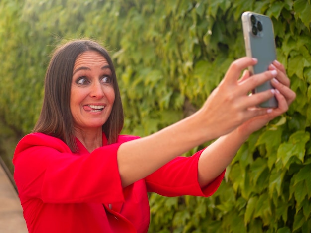 Fröhliche Frau, die sich in der Nähe einer Traubenhecke selbst macht