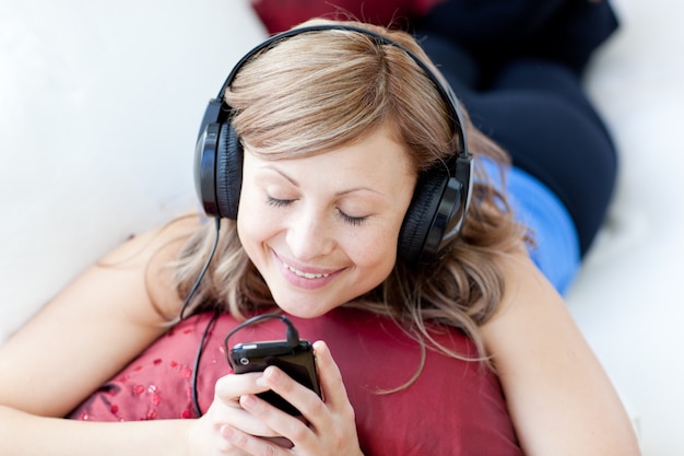 Fröhliche Frau hört die Musik im Wohnzimmer