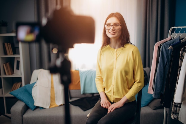 Fröhliche Frau mit Brille, die ein neues Video für einen Blog dreht