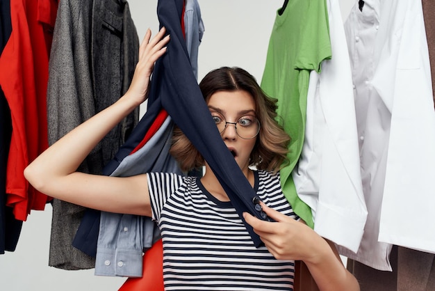 Foto fröhliche frau mit brille neben kleidung mode spaß einzelhandel emotionen