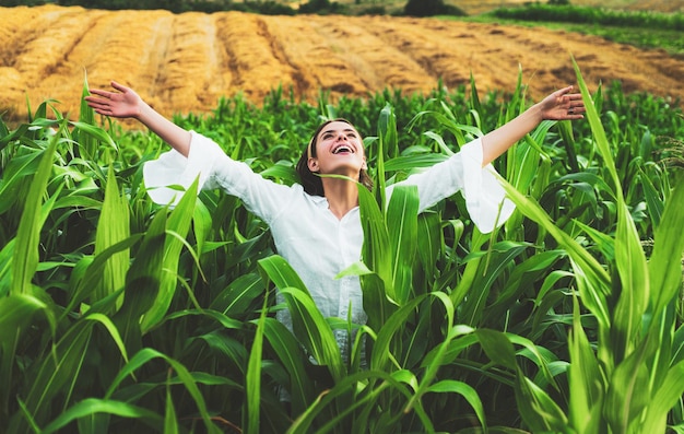 Fröhliche Frau posiert in der Maisernte Landwirtschaft und Anbaukonzept amerikanische Frau in einem Weiß
