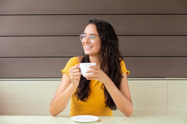 Fröhliche Frau trinkt Kaffee im Café