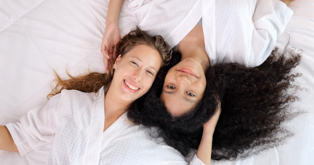 Fröhliche Frauen mit engen Freunden zeigen ein glückliches Gesicht und lächeln in die Kamera