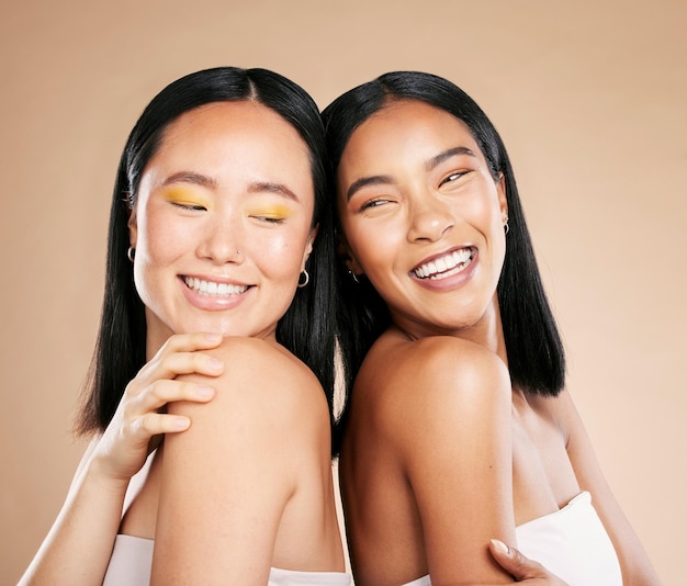 Fröhliche Frauenvielfalt und Make-up für Schönheitspflege und Dermatologie-Kosmetik im Studio Asiatische und schwarze Personenfreunde zusammen für Hautglanz-Spa-Gesichts- und Luxus-Gesichtskosmetikprodukte