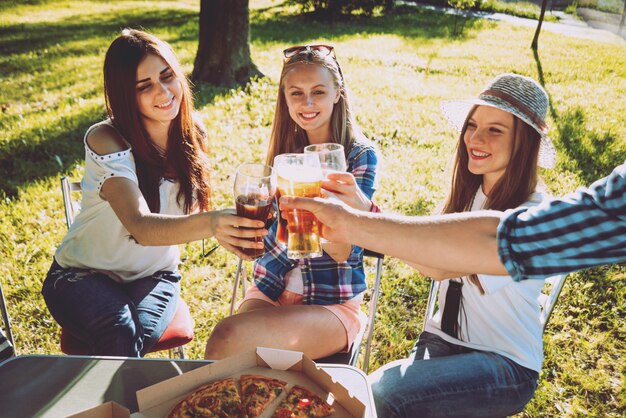 Fröhliche Freunde beim Picknick im Park. Pizza essen