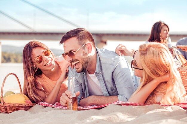 Fröhliche Freunde, die am Strand feiern