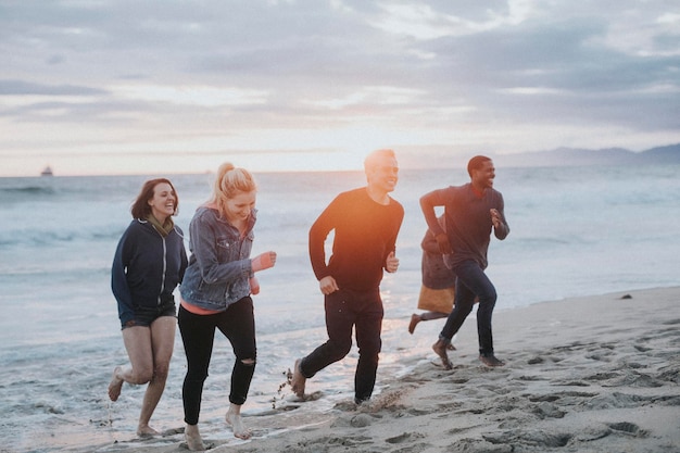 Fröhliche Freunde, die am Strand laufen