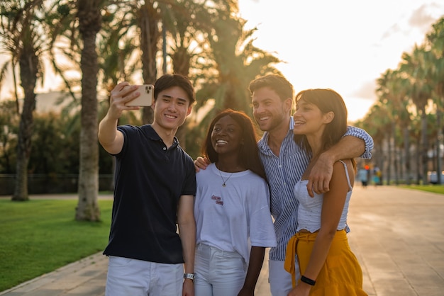 Fröhliche Freunde, die Selfie in der Nähe von Palmen machen