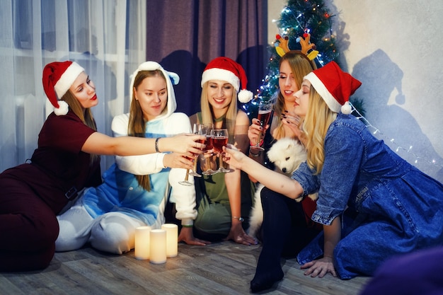Fröhliche Freunde feiern Neujahr mit einem Glas Champagner und Toasten zu Hause
