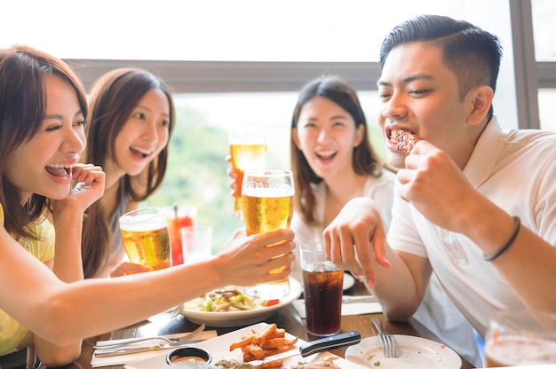 Fröhliche Freunde genießen Essen und Trinken im Restaurant