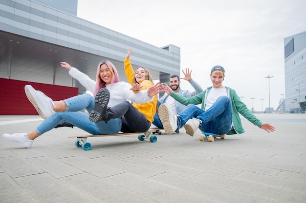 Fröhliche Freunde sitzen auf einem Skateboard