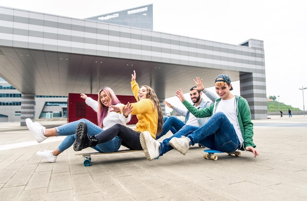 Fröhliche Freunde sitzen auf einem Skateboard