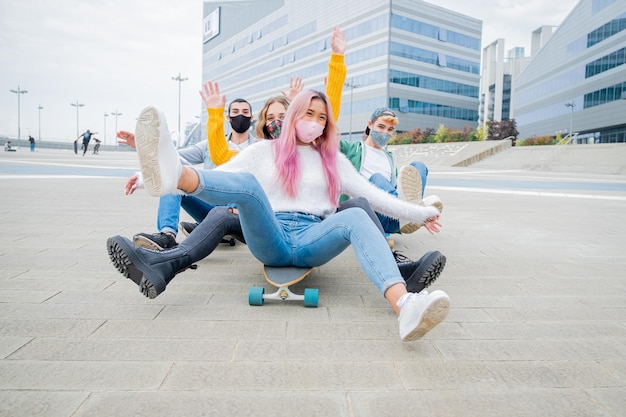 Fröhliche Freunde sitzen auf einem Skateboard