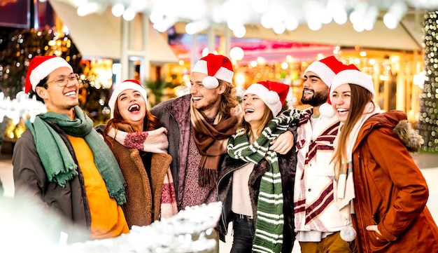 Fröhliche Freundesgruppe, die in den Weihnachtsferien in der Stadt spazieren geht