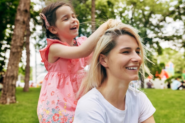 Fröhliche, fröhliche Frau, die mit dem Haar spielt, lächelnd und lachend posiert auf weißem Hintergrund Schöne glückliche Frau lächelt breit mit gesunden weißen Zähnen und wehenden Haaren isoliert auf weißer Wand