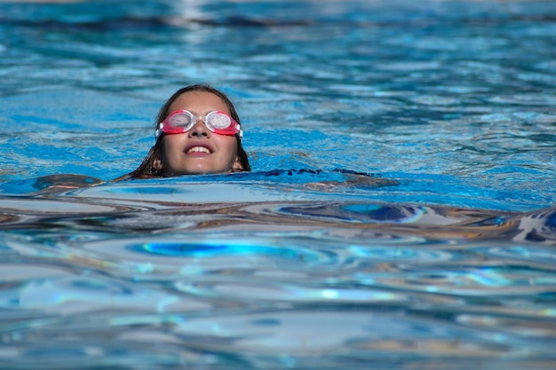 Fröhliche fröhliche Kinder im Pool des Hotels im Sommer. touristische Badesaison für Kinder auf See