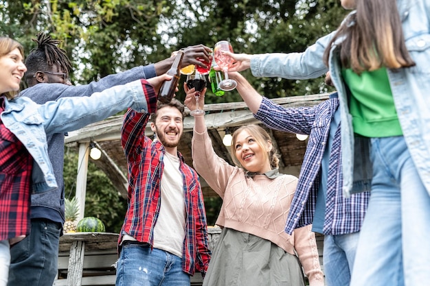 Foto fröhliche gemischtrassige menschen, die sich bei einer familienfeier auf dem dach amüsieren, während sie in der chiringuito-bar multikulturelle freunde trinken, die geburtstag oder ein anderes ereignis feiern