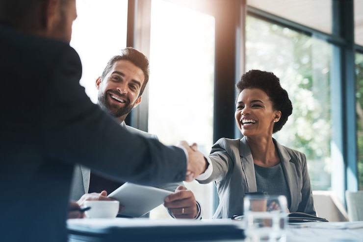 Foto fröhliche geschäftsleute schütteln sich die hand und treffen sich in teamarbeit für partnerschaft oder zusammenarbeit im sitzungssaal. frau schüttelt hände bei team-recruiting-einführung oder b2b-vereinbarung am arbeitsplatz
